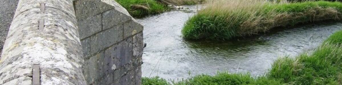 Photo "Collyweston Bridge Looking over the parapet of Collyweston Bridge from the Northamptonshire side of the River Welland to the Rutland side." by Graham Horn (Creative Commons Attribution-Share Alike 2.0) / Cropped from original