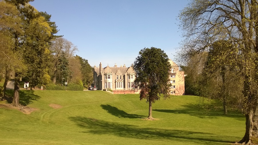 Photo "The Robert Gordon University, Aberdeen, Scotland: Garthdee House seen across lawn (to left of monkey puzzle tree). To the right of the tree is the Square Tower student residences." by undefined (Creative Commons Zero, Public Domain Dedication) / Cropped from original