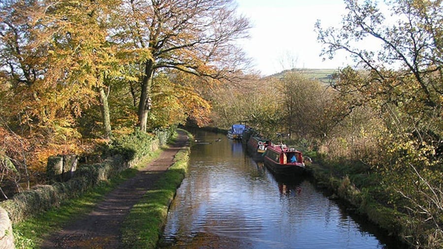 Photo "Bugsworth arm, Peak Forest Canal. This arm of the Peak Forest Canal leads for about a mile to the former wharf at Bugsworth Basin, and formerly connected with the Peak Forest Tramway. The Basin has recently reopened after water leakage problems scuppered an earlier restoration. Taken from the footbridge at the junction with the main navigation." by Dave Dunford (Creative Commons Attribution-Share Alike 2.0) / Cropped from original