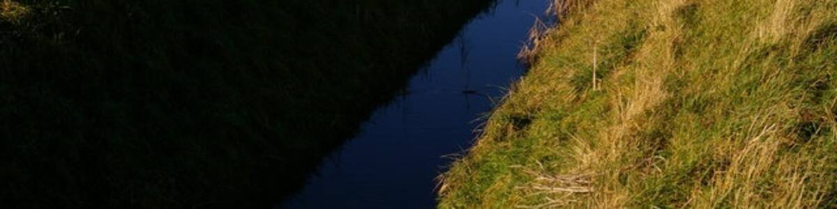 Photo "Buildings on Crabb's Abbey Farm Looking across the fields from Common Drove on a winter's afternoon." by Ben Harris (Creative Commons Attribution-Share Alike 2.0) / Cropped from original