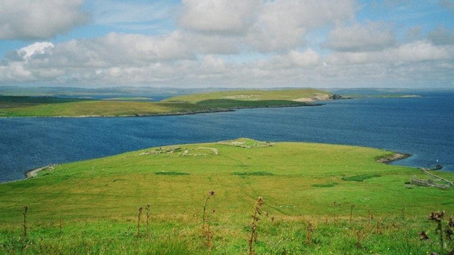 Photo "Ruined St Mary's chapel and Aith Ness peninsula on Bressay with Shetland Mainland in the background, Shetland, Scotland" by Ian Moodie (Creative Commons Attribution-Share Alike 2.0) / Cropped from original