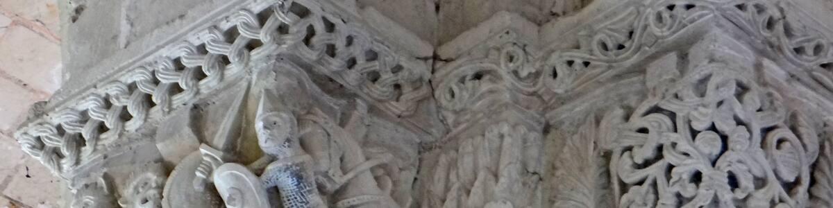 Photo "Chapiteaux dans la nef de l'église Le personnage avec un bouclier, une épée, une côte de maille et un cheval pourrait être un croisé (Foulque V (?), comte d'Anjou et du Maine) qui combat un barbare ou un être monstrueux." by Jean-Pierre Dalbéra (Creative Commons Attribution 2.0) / Cropped from original