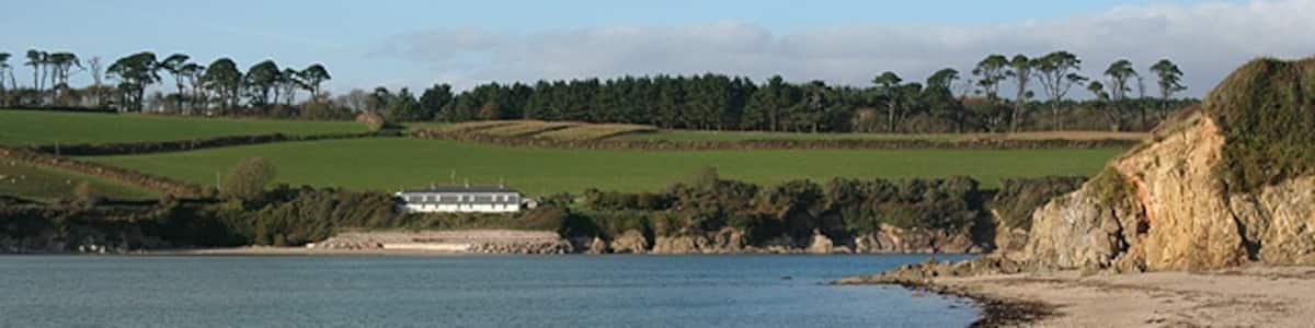 Photo "Kingston: Wonwell Beach View towards old coastguard cottages now serving as holiday homes" by Martin Bodman (Creative Commons Attribution-Share Alike 2.0) / Cropped from original