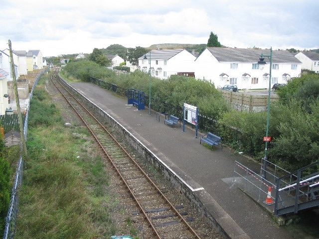 Bugle Station. This station on the Newquay branch line used to be an island platform. The second line ran in the now overgrown area between the platform and the white buildings at right. The station now only has pedestrian access, the station yard having been used for housing.