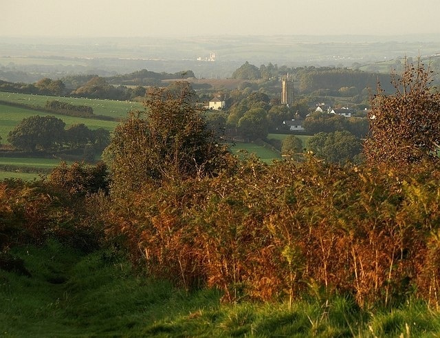 Towards South Tawton from Ramsley Hill. A path descends from the top of Ramsley Hill between high bracken and bramble. The elements in the middle distance are in SX6594, including the tower of South Tawton church. In the distance is 335844, about 8 km away.