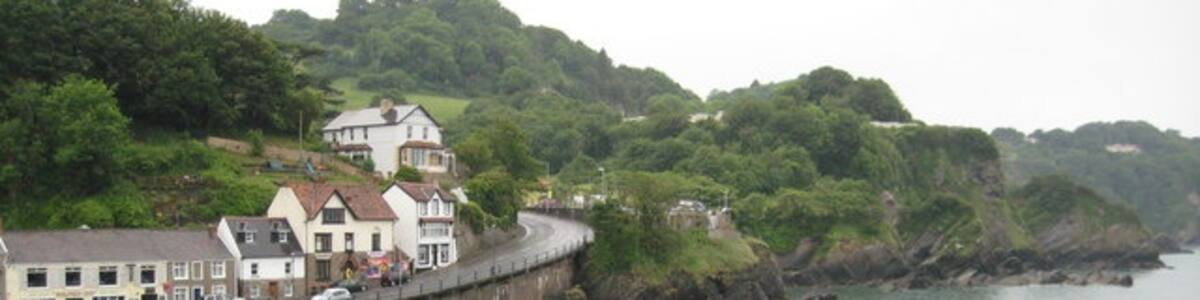 Photo "The beach at Combe Martin Beyond the beach is the A399 road to Ilfracombe." by Philip Halling (Creative Commons Attribution-Share Alike 2.0) / Cropped from original