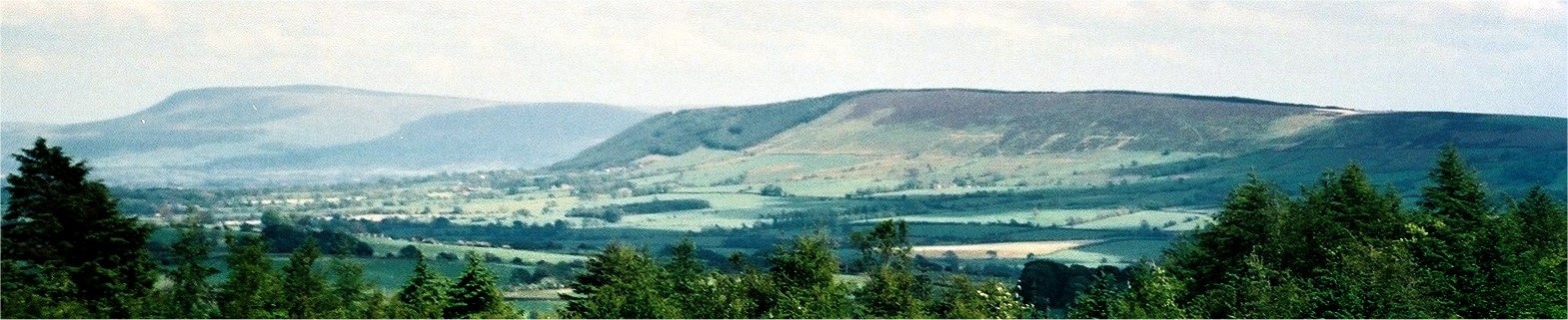 The east end of Longridge Fell, in Lancashire, England. Behind and to the left is Pendle Hill. Photographed from Beacon Fell.