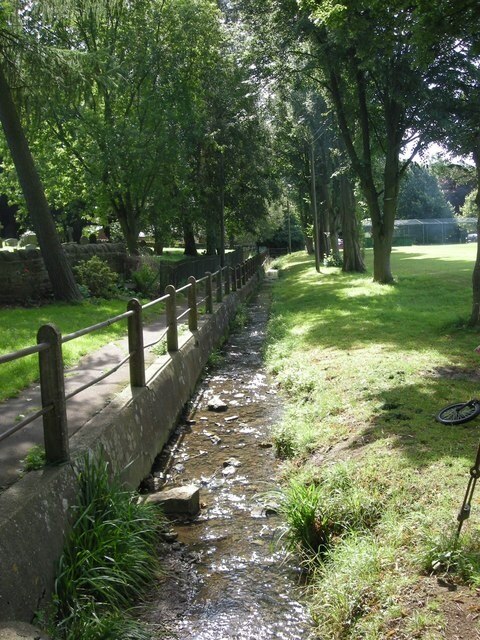 Byfield stream The stream and footpath separate the churchyard from the playing field.