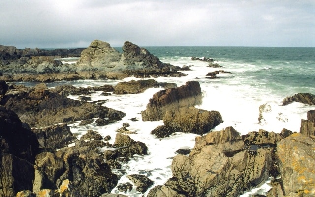 Portsoy. Rocky bays west of the harbour at Portsoy. The stacks of greenish-grey rock in the middle distance are part of the 'Portsoy Marble' outcrop, widely used for decorative purposes. It isn't in fact a marble at all; it is serpentinite.