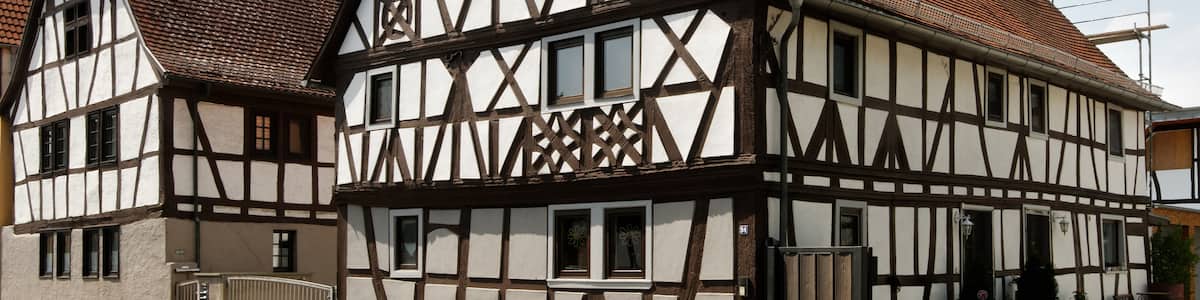 Photo "Fachwerkhaus in Froschhausen, einem Stadtteil von Seligenstadt (Hessen). Erbaut um 1700. Das Fachwerk ist reich verziert, unter anderem mit verschlungenen Rad- und Rautenornamenten." by E-W (Creative Commons Attribution-Share Alike 3.0) / Cropped from original