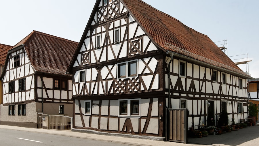 Photo "Fachwerkhaus in Froschhausen, einem Stadtteil von Seligenstadt (Hessen). Erbaut um 1700. Das Fachwerk ist reich verziert, unter anderem mit verschlungenen Rad- und Rautenornamenten." by E-W (Creative Commons Attribution-Share Alike 3.0) / Cropped from original