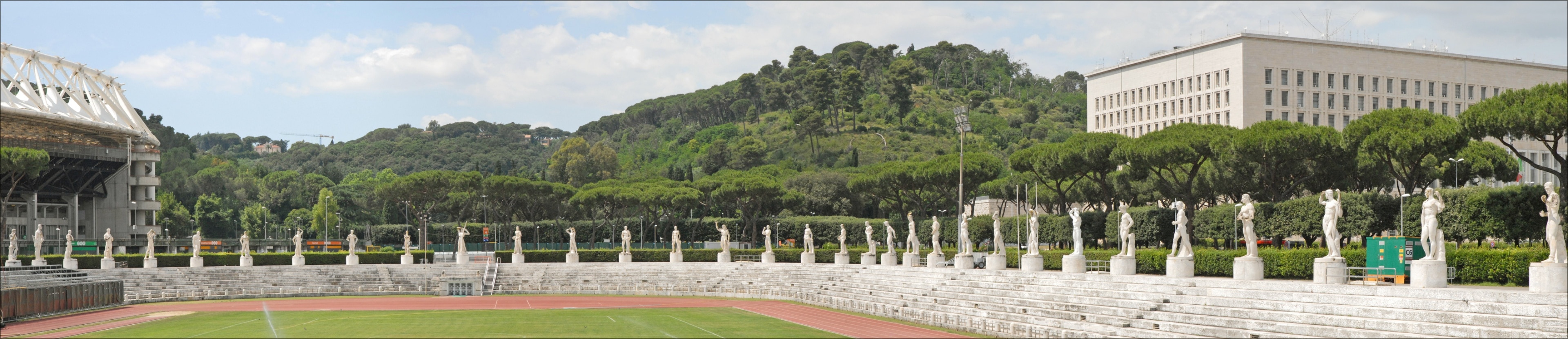 Le stade des marbres (Photo panoramique) A gauche, le stade olympique ____________ Le Foro Italico, appelé dans les années 30, Foro Mussolini, est un grand ensemble de bâtiments et d'équipements sportifs. Sa construction a débuté à l'époque fasciste sous la direction de l'architecte Enrico Del Dubbio. Le Foro a été inauguré en 1932. A l'entrée, un obélisque en marbre dédié à Mussolini a été érigé. Le stade des marbres est l'équipement le plus célèbre avec ses 60 statues d'athlètes à l'antique, placées au-dessus des gradins et offertes par les villes et provinces d'Italie. A l'entrée, se trouvait l'Académie d"éducation physique, constituée de deux corps de bâtiments rouges, symétriques et reliés par une loggia. Les locaux sont occupés aujourd'hui par le comité olympique italien. A proximité, un stade olympique a été construit pour les jeux de 1960 puis agrandi pour la coupe du monde de 1990.