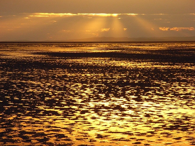 Solway sunset Wet sand at low tide with Kirkcudbrightshire just visible.