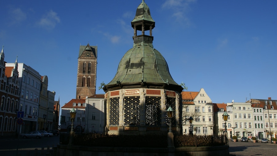 Photo "Tower of the Marienkirche (St. Mary Church) and Wasserkunst, former water supply fountain, at the market square in Wismar, Germany" by undefined (Creative Commons Zero, Public Domain Dedication) / Cropped from original