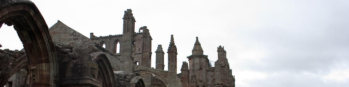 Photo "Melrose Abbey is located in Melrose, Scotland. It was built in 1138 and abandoned in 1609; it is now a ruin. It is considered to be one of the most beautiful church buildings in the United Kingdom." by LeCardinal (Creative Commons Attribution 3.0) / Cropped from original