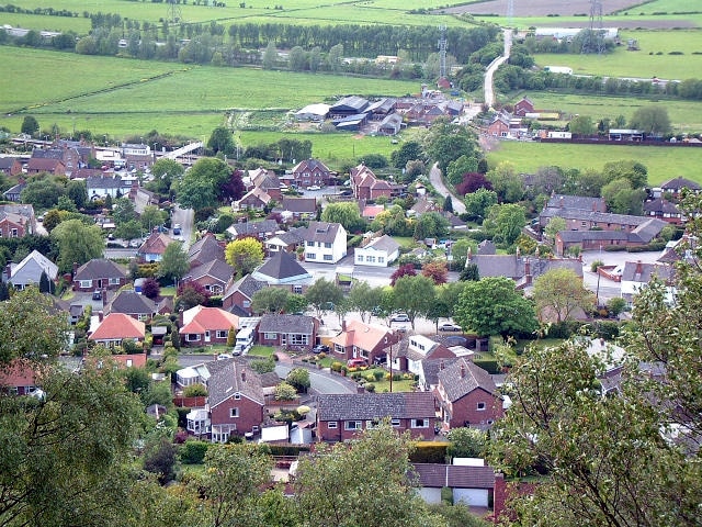 Helsby Village. As seen from the very steep sandstone hill to the east. Taken from 492755 looking north west, the minor road bridge over the M56 can be seen towards the top of the picture with the radio/telephone mast close by.