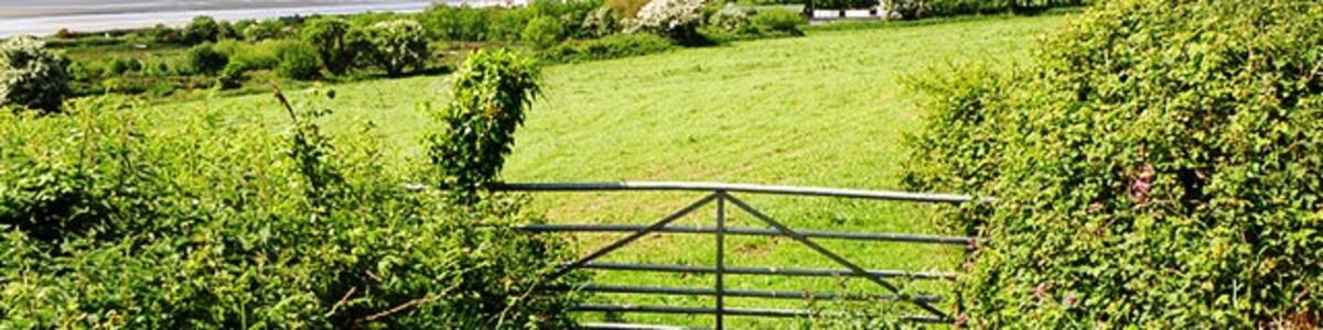Photo "Looking towards the sea Farmland near Kidwelly. In the distance can be seen Gwendraeth, the mouth of Gwendraeth Fawr, as it reaches the sea at the same point as the Rivers Towy and Taf." by Stuart Wilding (Creative Commons Attribution-Share Alike 2.0) / Cropped from original