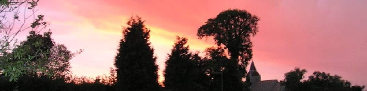 Photo "Sunset at Pidley, Cambridgeshire (formerly Huntingdonshire), silhouetting trees and (centre right) All Saints' parish church" by Emma Beecroft (Creative Commons Attribution-Share Alike 2.0) / Cropped from original