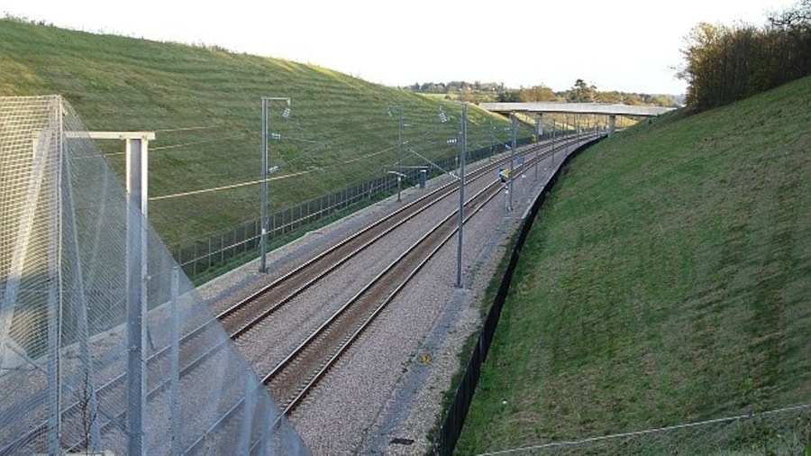 Photo "Channel Tunnel Rail Link. Looking SE from bridge 831 on Boughton Road. The railway runs through a deep cutting at this point and, a little way to the west, it runs through a short tunnel but the noise from the nearby M20 motorway is horrendous. The bridge in the distance is Lenham Heath Road." by Penny Mayes (Creative Commons Attribution-Share Alike 2.0) / Cropped from original