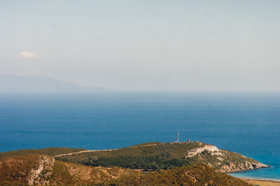 The Coscia cape (Punta di a Coscia) supporting ruins of a windmill, north of Macinaggio, Rogliano, Haute-Corse (Corsica). The Tuscan archipelago can be seen in the distance.