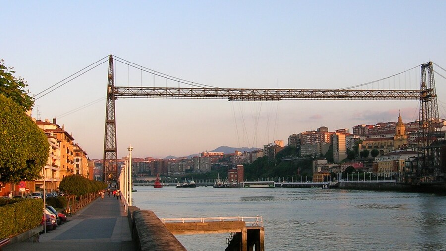 Photo "Bizkaia Zubia (Biscay Bridge) Transporter Bridge between Portugalete a Las Arenas - Areeta. The upper horizontal span is a footbridge that can be accessed through lifts (elevators)." by Javierme (Creative Commons Attribution-Share Alike 2.0) / Cropped from original