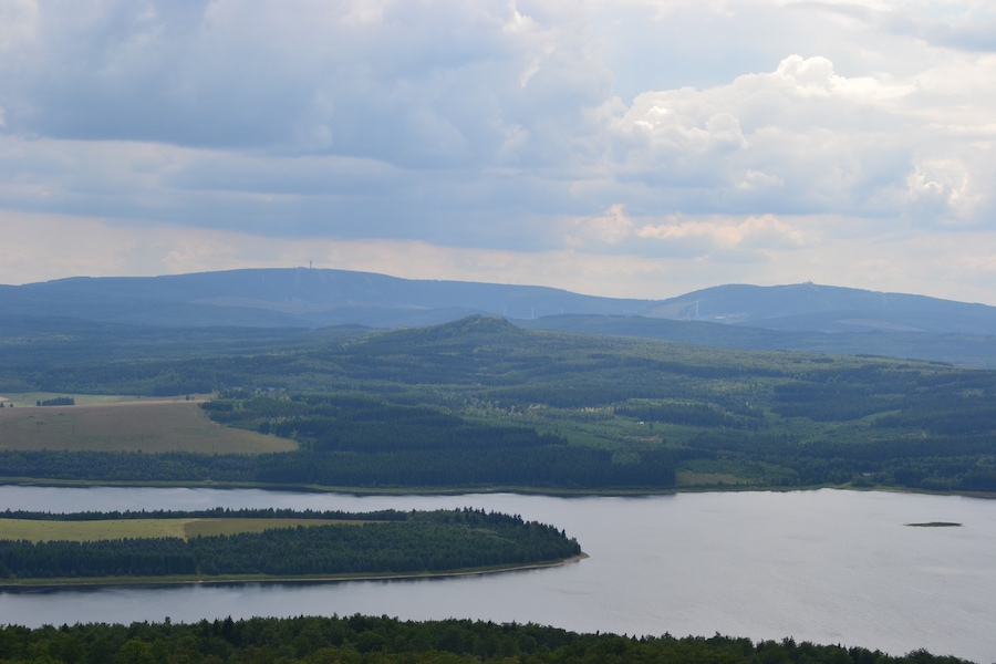 Blick vom Jelení hora nach Südwest. Im Hintergrund das Fichtelberg-Keilberg-Massiv, in Bildmitte der Velký Špičák und im Vordergrund ist ein Teil des Stausees der Talsperre Preßnitz erkennbar.