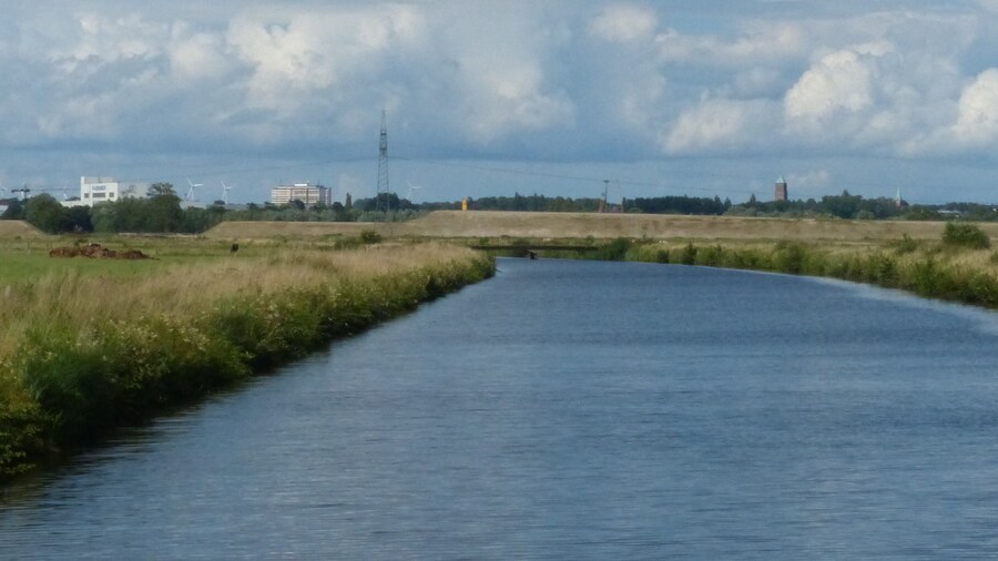 Photo "Motzener Kanal, im Hintergrund Straßendamm für die Neutrassierung der B 212, am Horizont rechts Wasserturm von Blumenthal" by Ulamm (Creative Commons Attribution-Share Alike 4.0) / Cropped from original