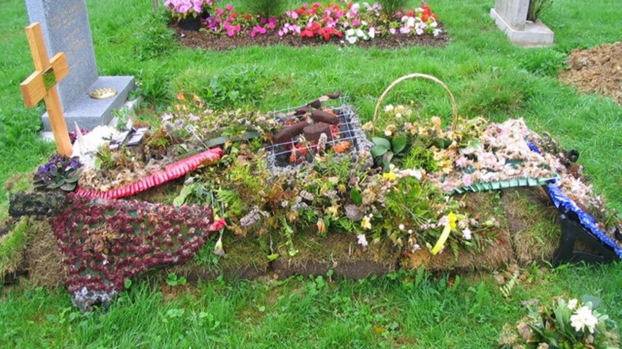 Photo "A floral tribute with a centrepiece of sausages, beefburger and kebab marking a recent grave in the churchyard at Thorpe-le-Soken." by M J Richardson (Creative Commons Attribution-Share Alike 2.0) / Cropped from original