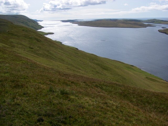 View over Clift Sound from Kame of Whal Wick Clift Sound is the drowned southern end of one of the several parallel valleys which run north-south through central Mainland. These hills are carved into thick phyllites.