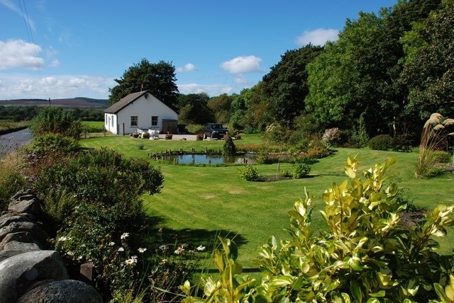 "Sealladhan Dheas" cottage, Bridgend This attractive cottage and garden lie alongside Clauchan Water. The stone wall to the left of the picture is part of the bridge over the burn and the road is the B880, leading into Shiskine.