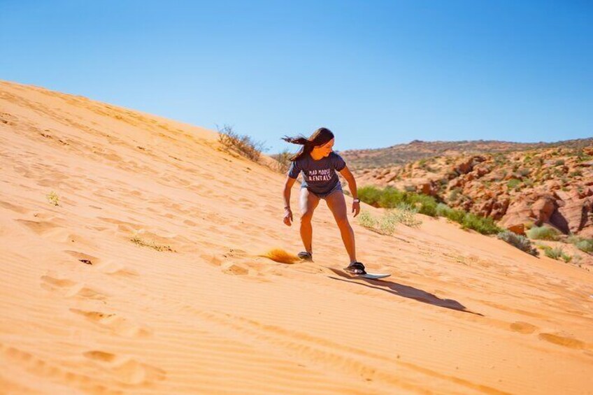 Sandboarding down a sand hill