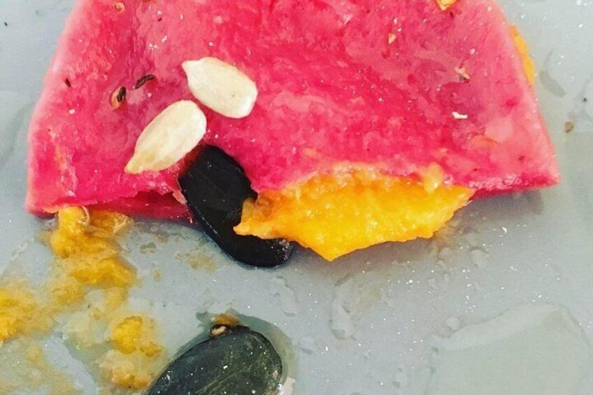 Beetroot ravioli filled with spiced sweet potato and topped with seeds and olive oil 
