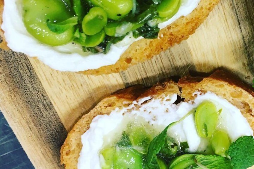 Crostini with whipped feta topped with broad beans , peas and mint 