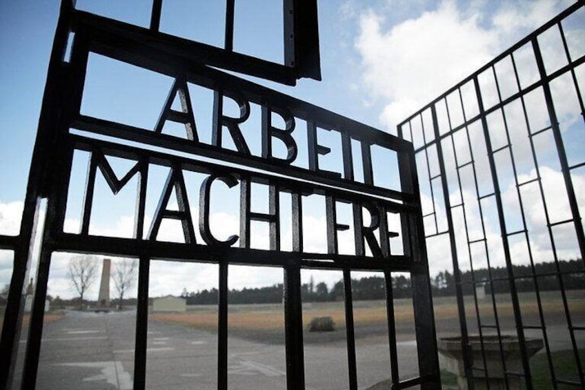 Enter the prison camp, passing the infamous "Arbeit Macht Frei" (work sets you free) sign