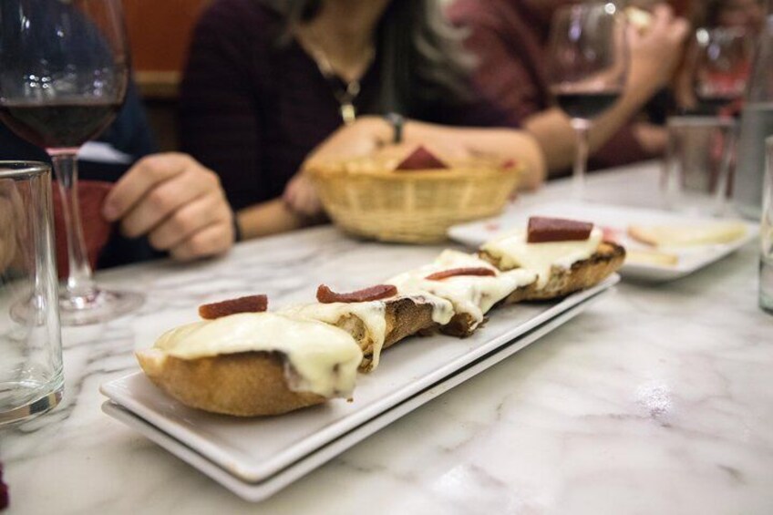 Restaurant guests bite into “manchego,” cheese made of sheep’s milk, with “membrillo,” or quince paste.