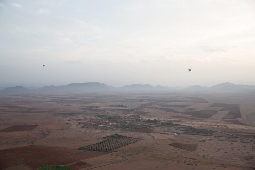 Almost but not quite obscured, the Atlas Mountains provide a picturesque backdrop for a hot air balloon ride from Marrakech.