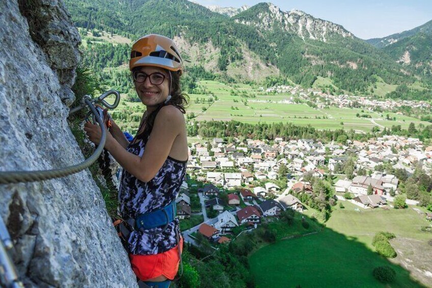 Excited female Via Ferrata climber with gorgeous view towards Mojstrana and Dovje Village