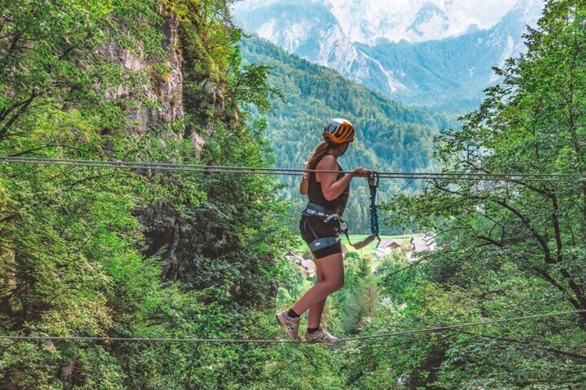 Female tourist, Passing the wire bridge on beautiful Via Ferrata tour near Kranjska Gora
