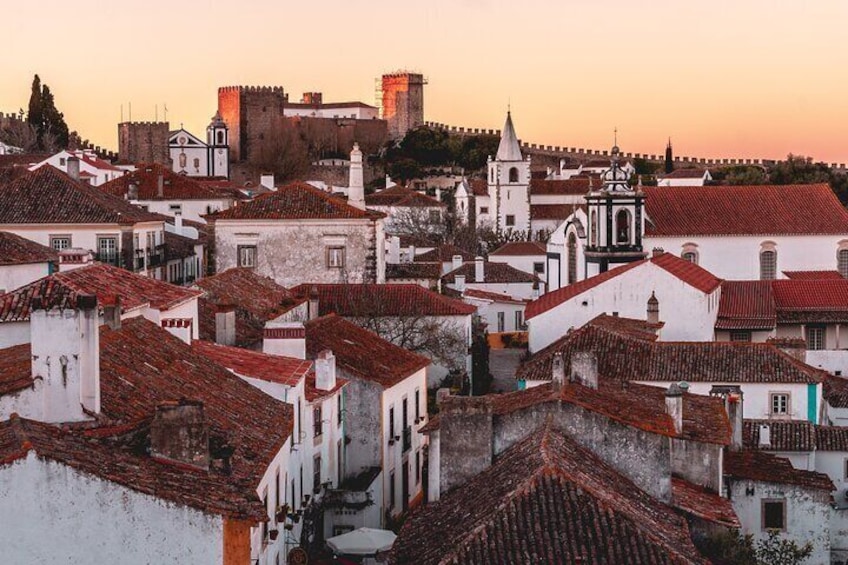 Óbidos is a medieval town with cobblestone streets and flower-bedecked, whitewashed houses