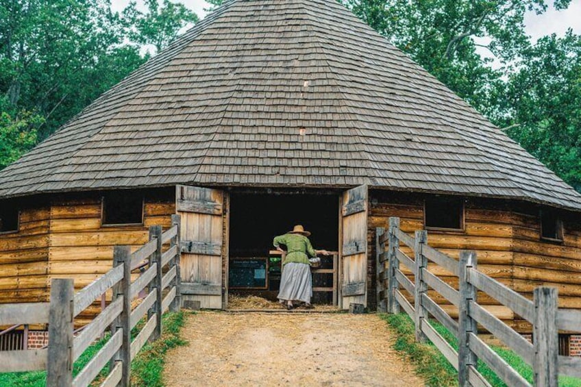 Dressed in period clothing, a guide opens Washington's 16-sided treading barn to visitors.