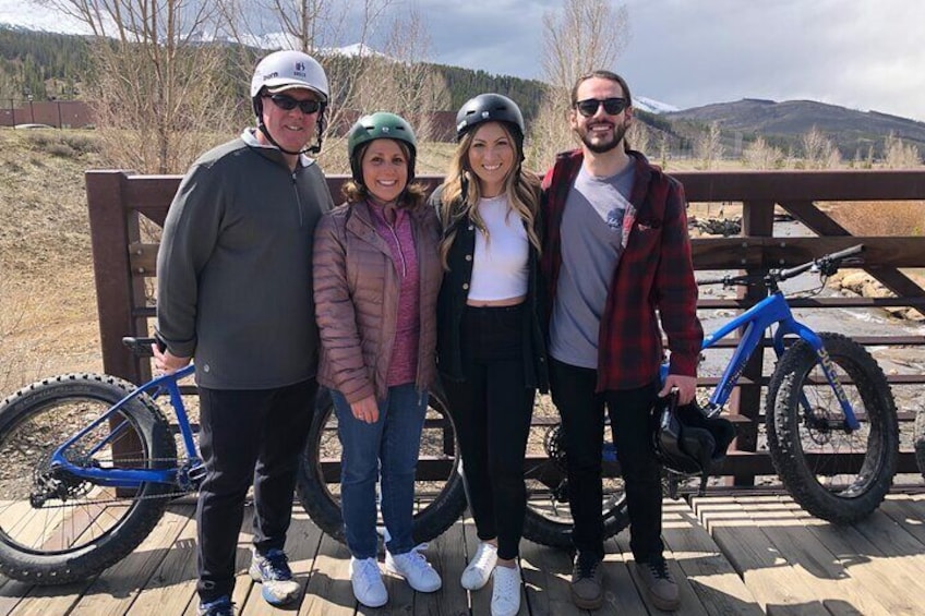 Another happy family biking by the river in the mountains 