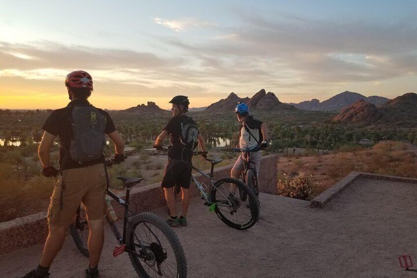 Guests taking in a view of the Valley of the Sun from Hunt's Tomb at sunset at Papago Park via mountain bike.