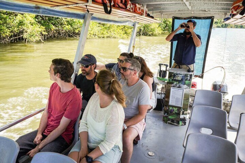 Guide spotting for wildlife along the Daintree River