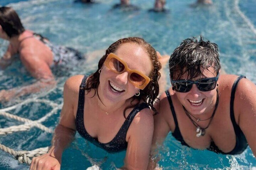 Two ladies having fun swimming in the boom net