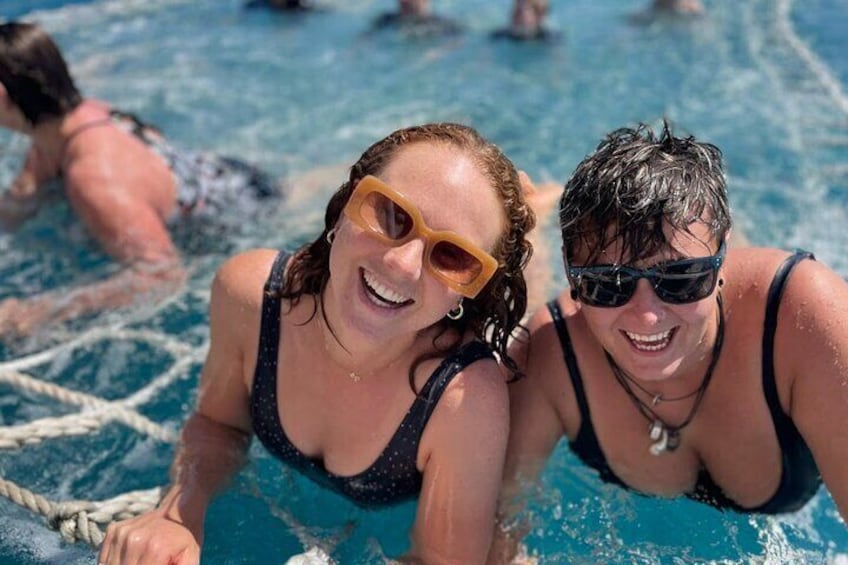 Two ladies having fun swimming in the boom net