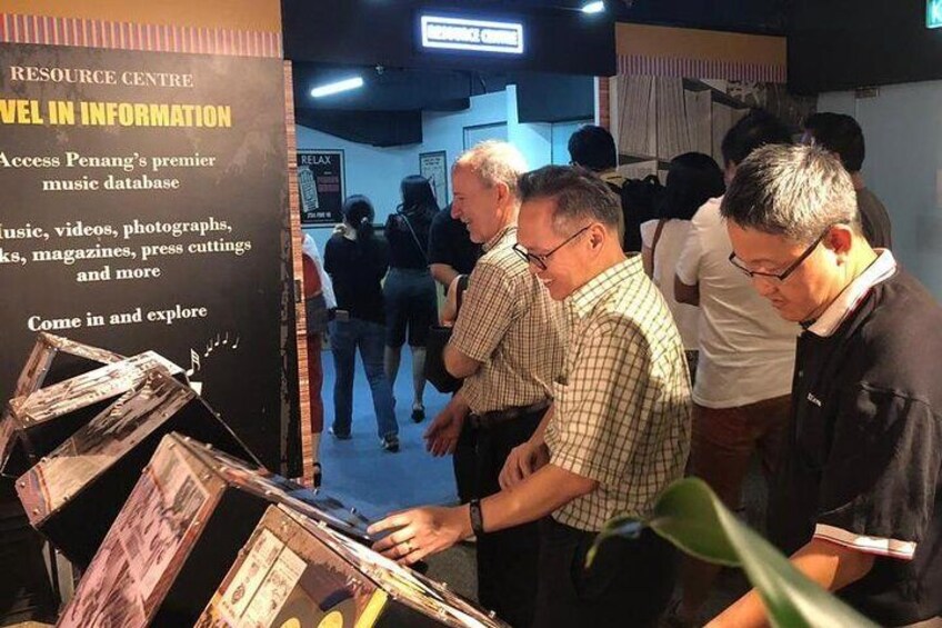 Visitors reading about the different entertainment venues in Penang