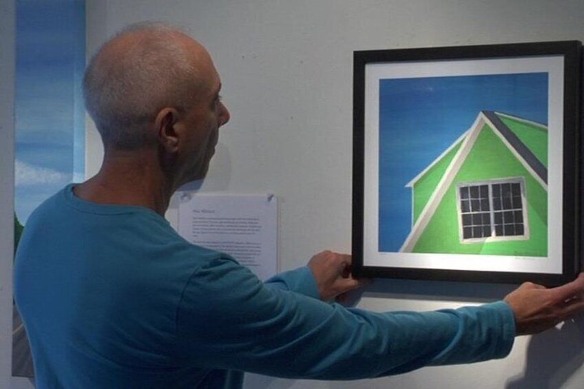 Paul adjusts a framed print of "Bungalow Shadow." 