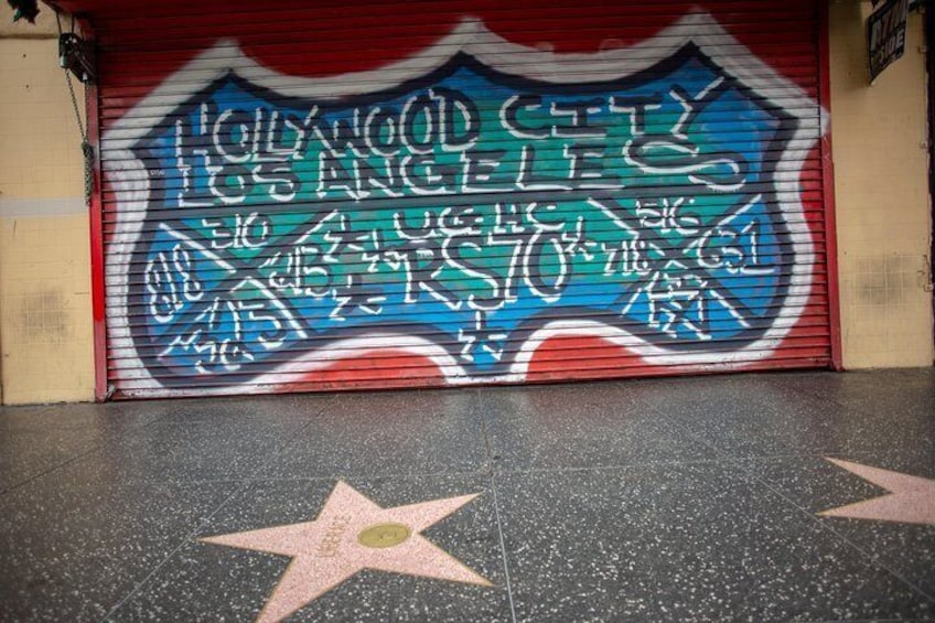 Street art frames a part of the Hollywood Walk of Fame which includes over 2,600 five-pointed stars and publicly celebrates the achievements of America’s entertainment industry.