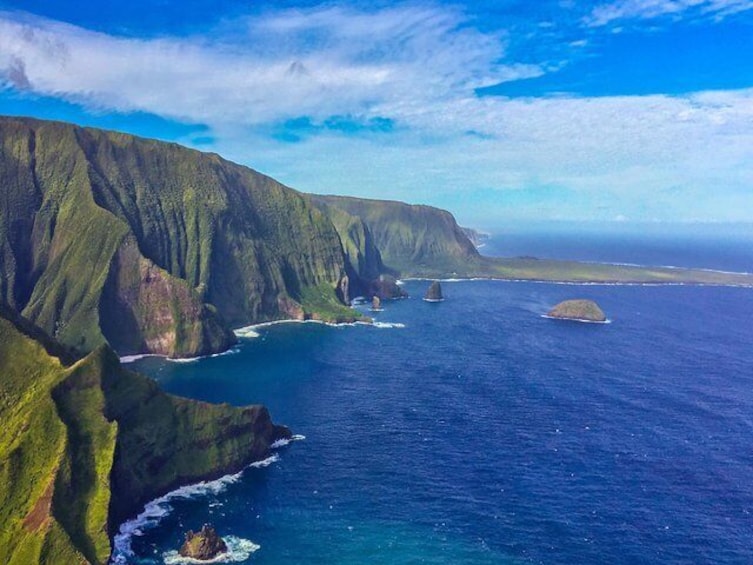 Lush green cliffs rise imposingly from the sea along West Maui's coastline.