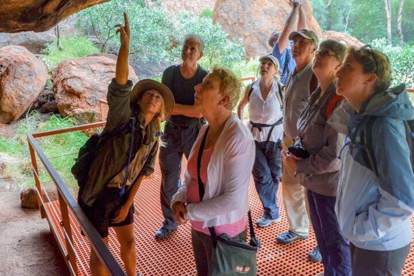 Look up to see rock art inside the caves around the base of Uluru.